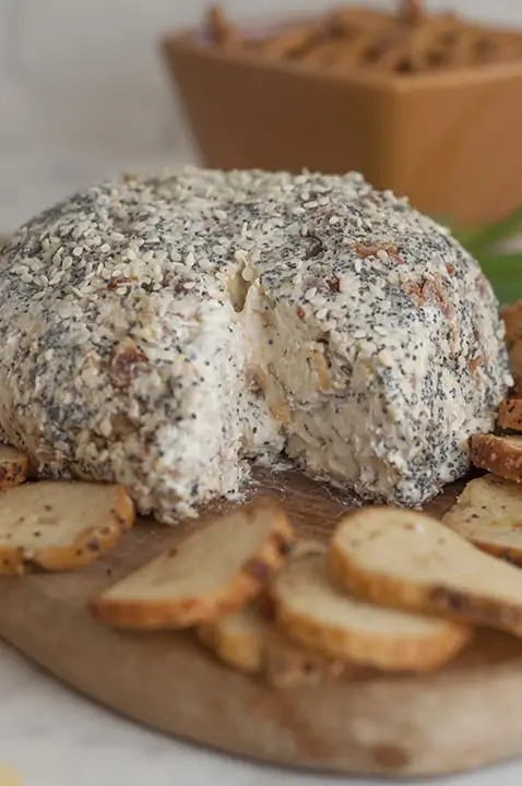 The Everything Bagel Cheese Ball has a small slice cut out and surrounded by bagel chips