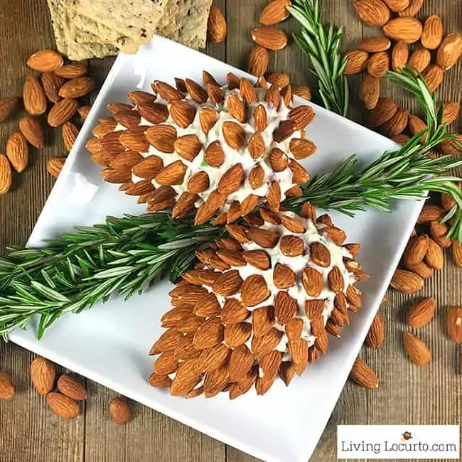 Two Pine Cone Cheese Ball with Almonds are on a square plate shaped as a pine cone with the help of the almonds