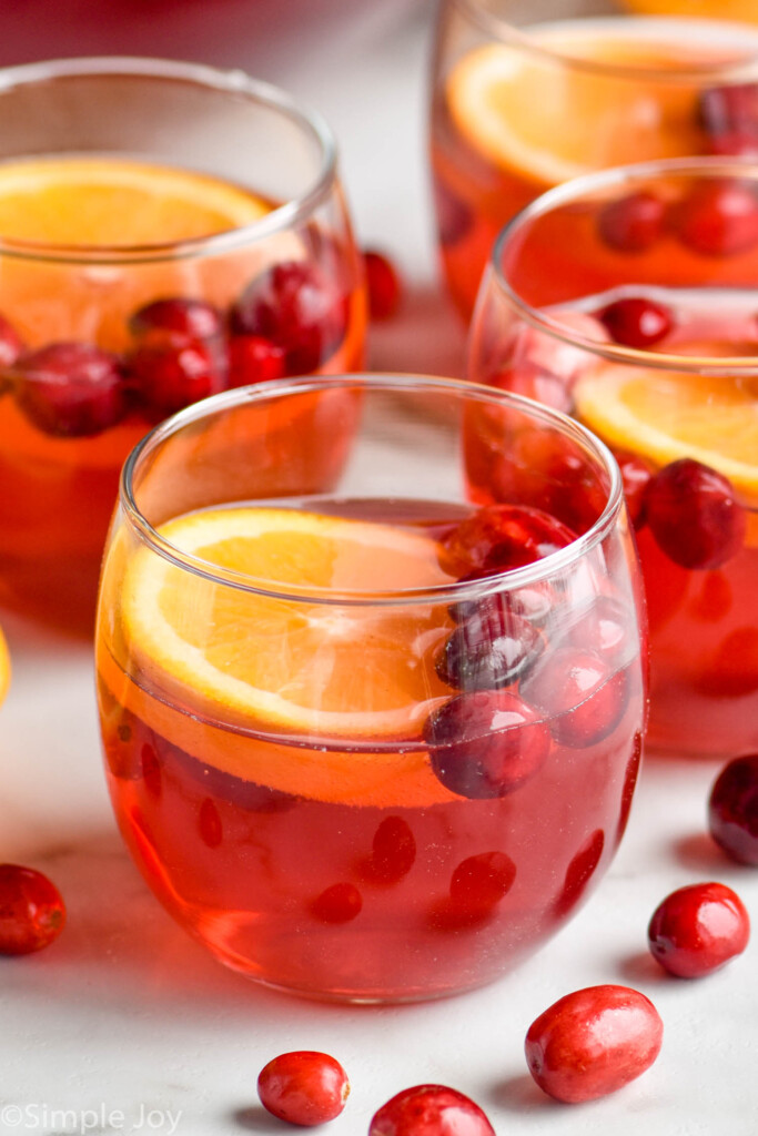 glass of christmas punch recipe with fresh cranberries and orange slice