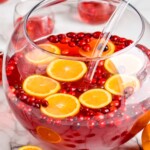 large punch bowl full of christmas punch with fresh cranberries and orange slices