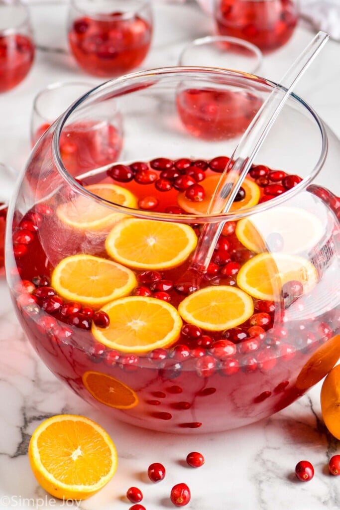 large punch bowl full of christmas punch with fresh cranberries and orange slices