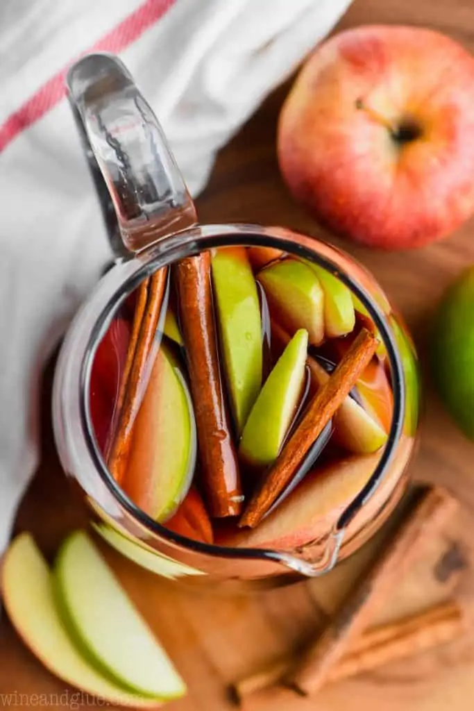 overhead view of a pitcher of cinnamon sangria with sliced apples and cinnamon sticks 