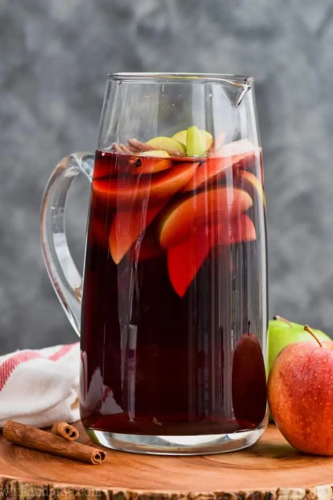 pitcher of cinnamon whiskey sangria recipe with sliced apples and cinnamon sticks 