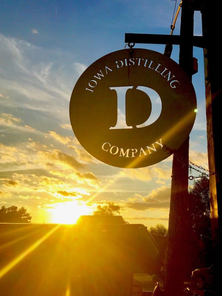 the metal sign hanging outside of the Iowa Distilling Company