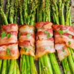 four asparagus bundles, wrapped in bacon after being baked
