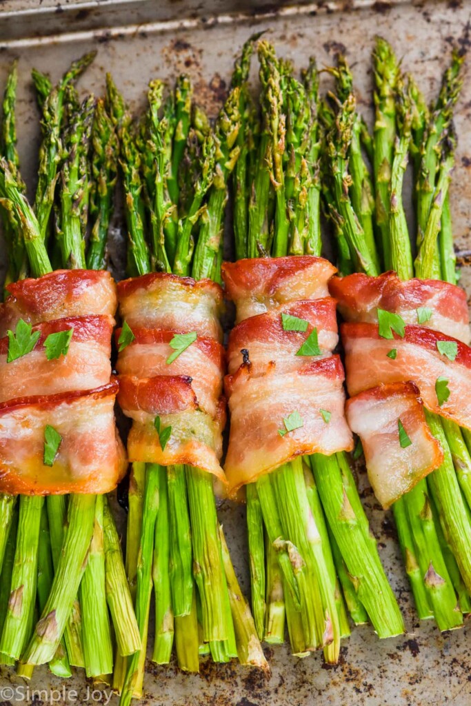 four asparagus bundles, wrapped in bacon after being baked