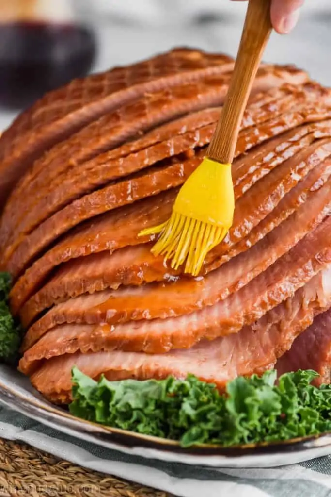 close up of brown sugar glaze for ham being brushed on