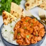 bowl of butter chicken with rice and naan
