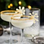 two christmas martinis garnished and in front of holiday lights - 7