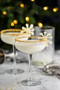 dos martinis de navidad con guarnición y delante de las luces navideñas