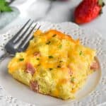 piece of ham and cheese overnight breakfast casserole on a white plate