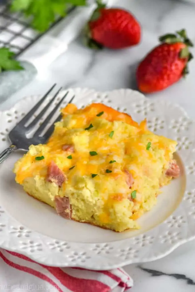 piece of ham and cheese overnight breakfast casserole on a white plate