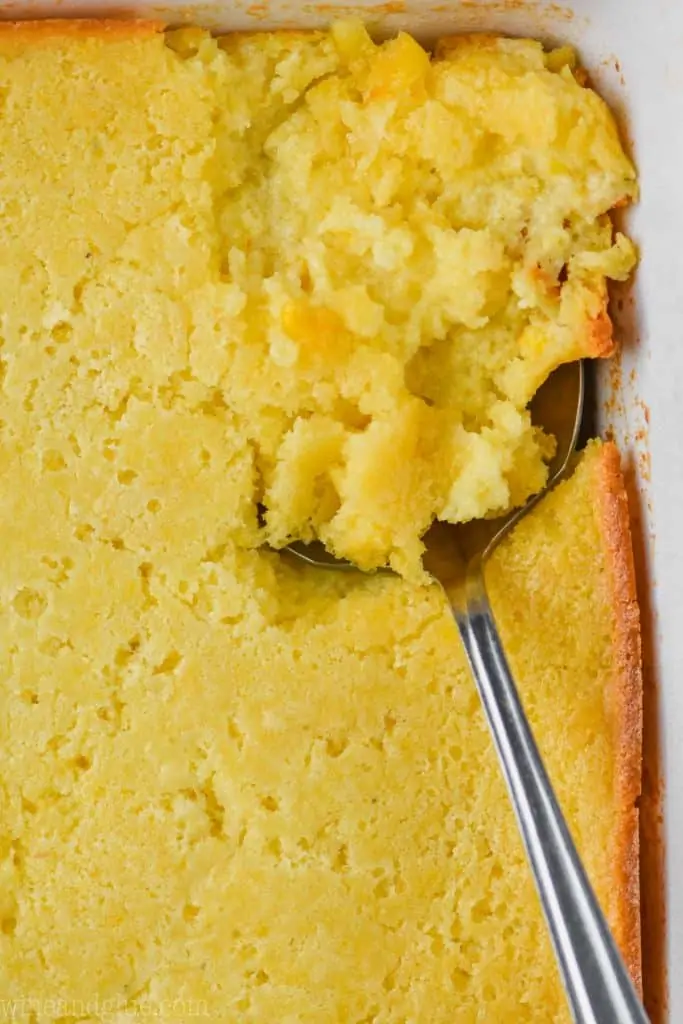 close up of spoon in casserole dish full of jiffy corn casserole