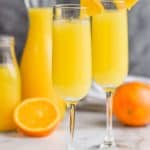 two mimosa mocktails garnished with oranges wedges - 17
