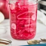 pinterest graphic of a fork pulling red onions out of a mason jar, says: "how to make: pickled red onions, simplejoy.com"