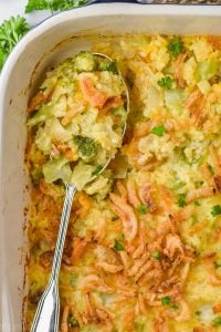 overhead view of a spoon in a casserole dish of broccoli rice casserole