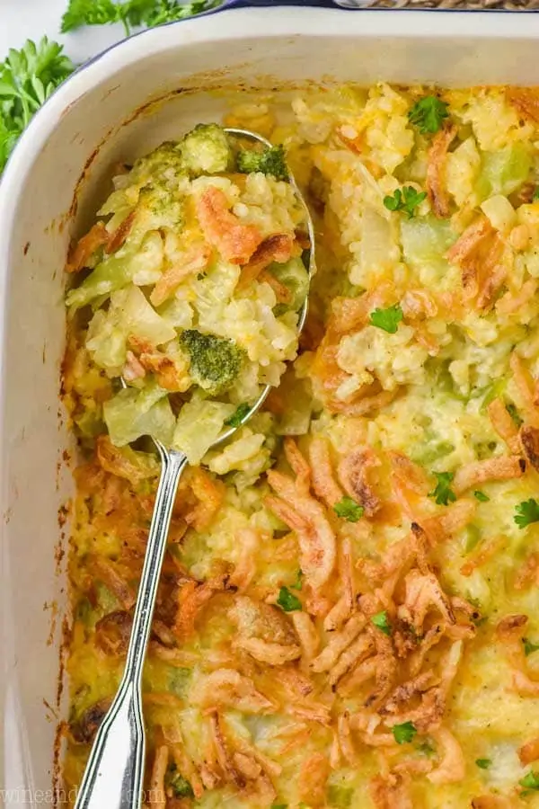 overhead view of a spoon in a casserole dish of broccoli rice casserole