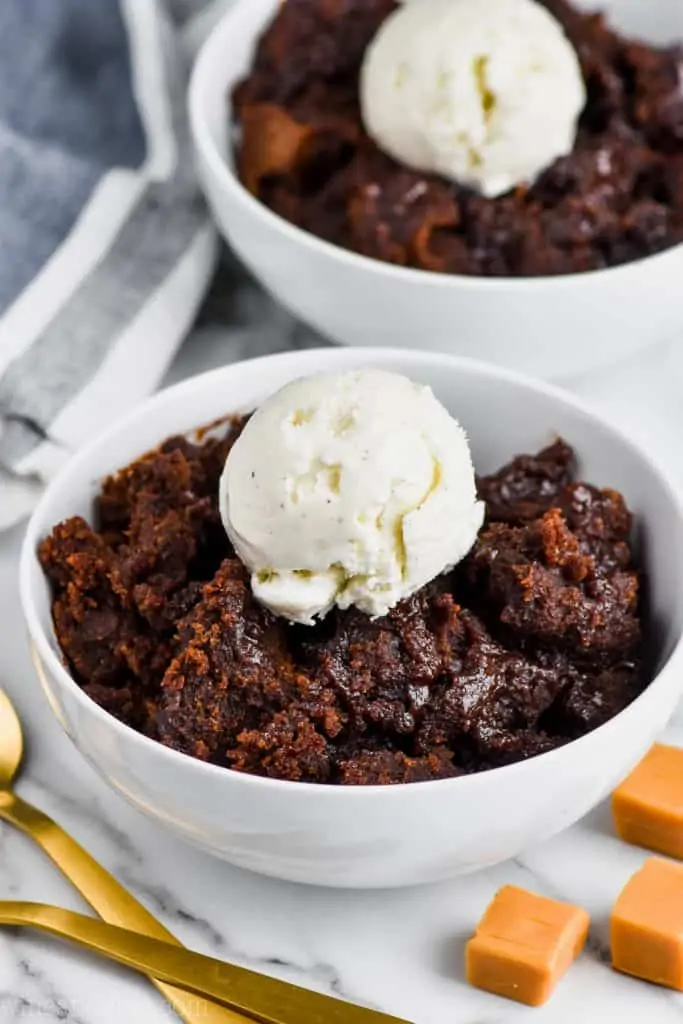 white bowl full of crock pot brownies with vanilla ice cream