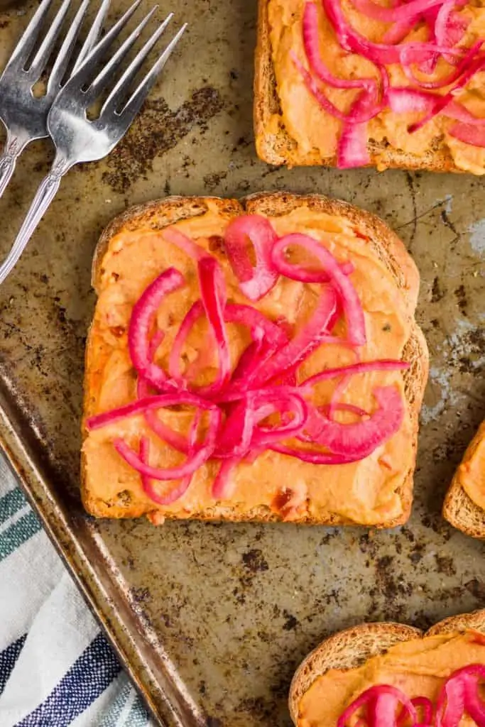 red pickled onions on a piece of hummus toast for an easy breakfast recipe