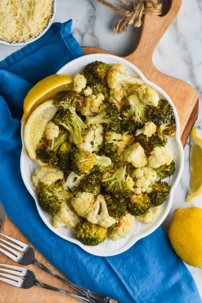 overhead view of white plate with roasted broccoli and cauliflower with parmesan