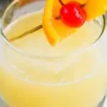 glass with of whiskey sour recipe garnished with an orange slice and a cherry