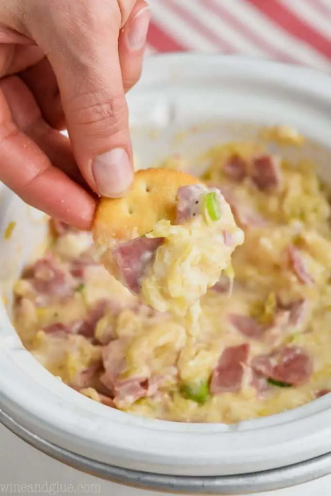 ritz cracker being dipped in hot reuben dip