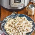 shredded instant pot chicken on a plate in front of an instant pot
