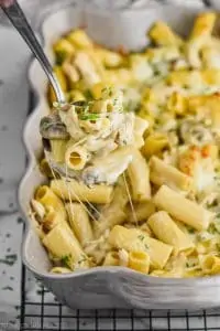 spoon dishing up marsala chicken noodle casserole from a baking dish