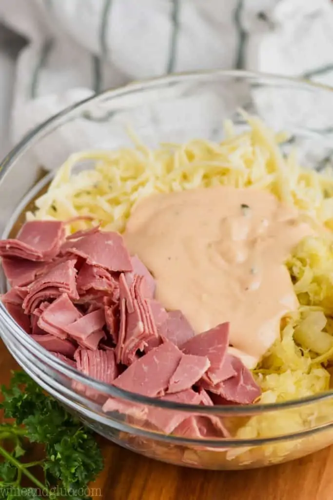 ingredients for reuben dip recipe in a clear bowl