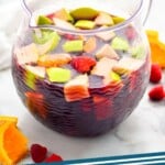 pinterest graphic of pitcher of red sangria with cut up apples, oranges, and raspberries, says: "red wine sangria"
