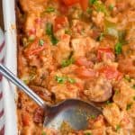 spoon digging into a casserole dish of cajun chicken and rice