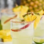 tumbler glass filled with spicy pineapple margarita and garnished with a chile pepper and a slice of pineapple - 10