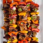 steak kabobs, skewered with metal skewers and flavored with fajita seasoning, on a white plate - 10