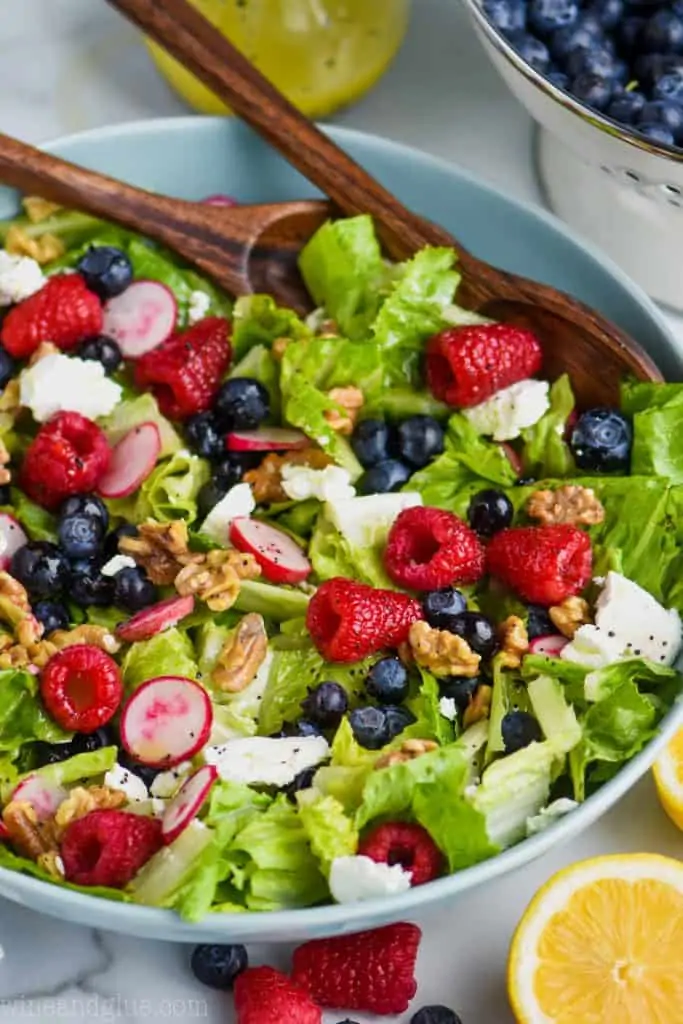 raspberries, blueberries, walnuts, goat cheese, radishes, and romain lettuce in a bowl for a great summer salad recipe