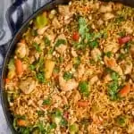 overhead view of peanut butter stir fry noodles in a large skillet, topped with fresh cilantro and chopped peanuts - 2