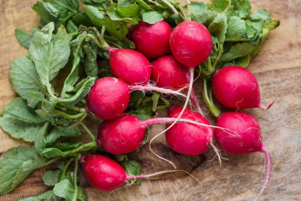 pile of fresh beets, uncut on a wooden cutting board