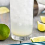 pinterest graphic of close up view of a gin rickey cocktail in a tall glass garnished with a lime wedge, says: "gin rickey simplejoy.com"