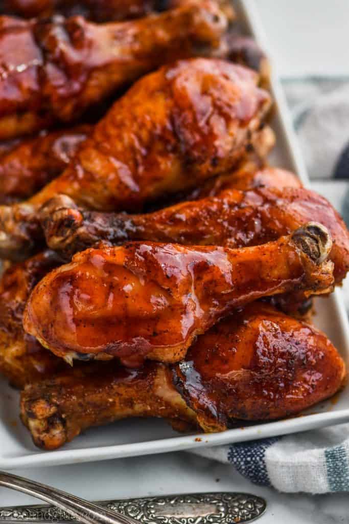 plate full of grilled chicken legs sitting on a striped napkin