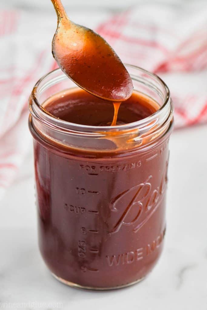 spoon dipping into a mason jar full of easy homemade bbq sauce