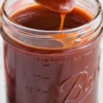 mason jar full of bbq sauce with spoon dishing some out