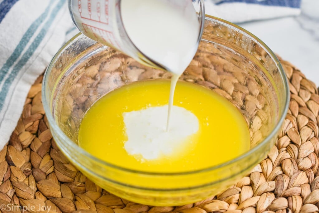 cold buttermilk being poured into hot melted butter to make easy biscuits