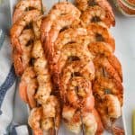 shrimp skewers, seasoned with cajun seasoning in a pile on a white rectangular dish - 7