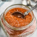 small mason jar filled of chicken rub mix with measuring spoon in it on a white marble counter - 5