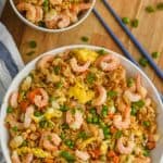 overhead view of bowl of shrimp fried rice recipe on a wood cutting board