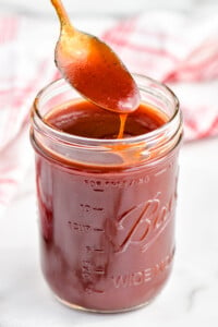 spoon dipping into a mason jar full of easy homemade bbq sauce