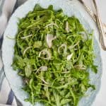 overhead view of an oval plate with an arugula salad on it - 5