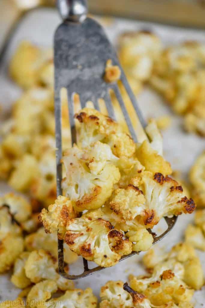 close up of oven roasted cauliflower on a slotted spatula, being dished up