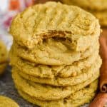 stack of pumpkin peanut butter cookies on wax paper on burlap with a cinnamon stick next to them and a bite out of the top cookie - 19