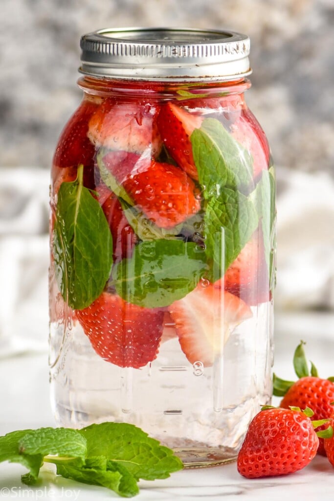 a mason jar full of fresh strawberries and fresh mint, to make fruit infused water