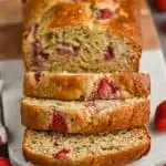 overhead view of strawberry banana bread sliced on a marble cutting board